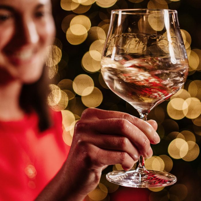 Isabella Cameron, fine wine specialist, holds a glass of white wine at Christmas