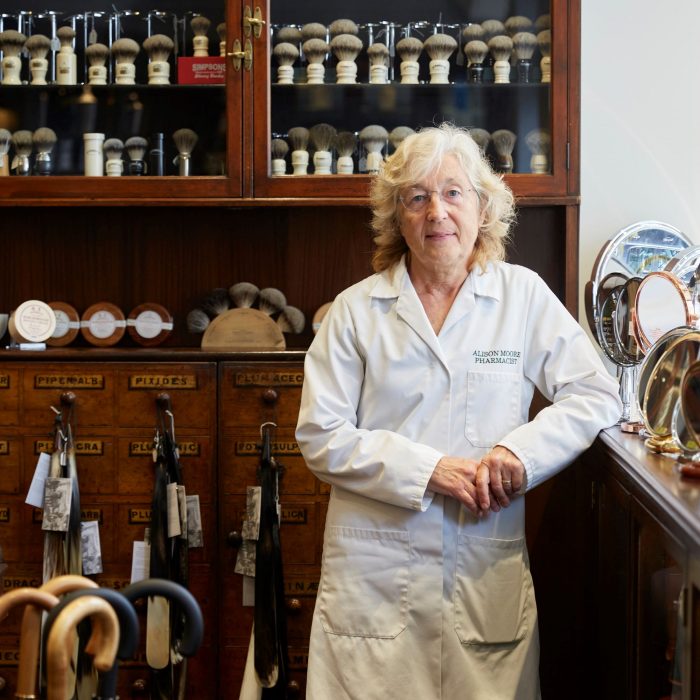 Pharmacist Alison Moore stands next to the wooden cabinets in pharmacist DH Harris, a mainstay of St James's for more than 200 years