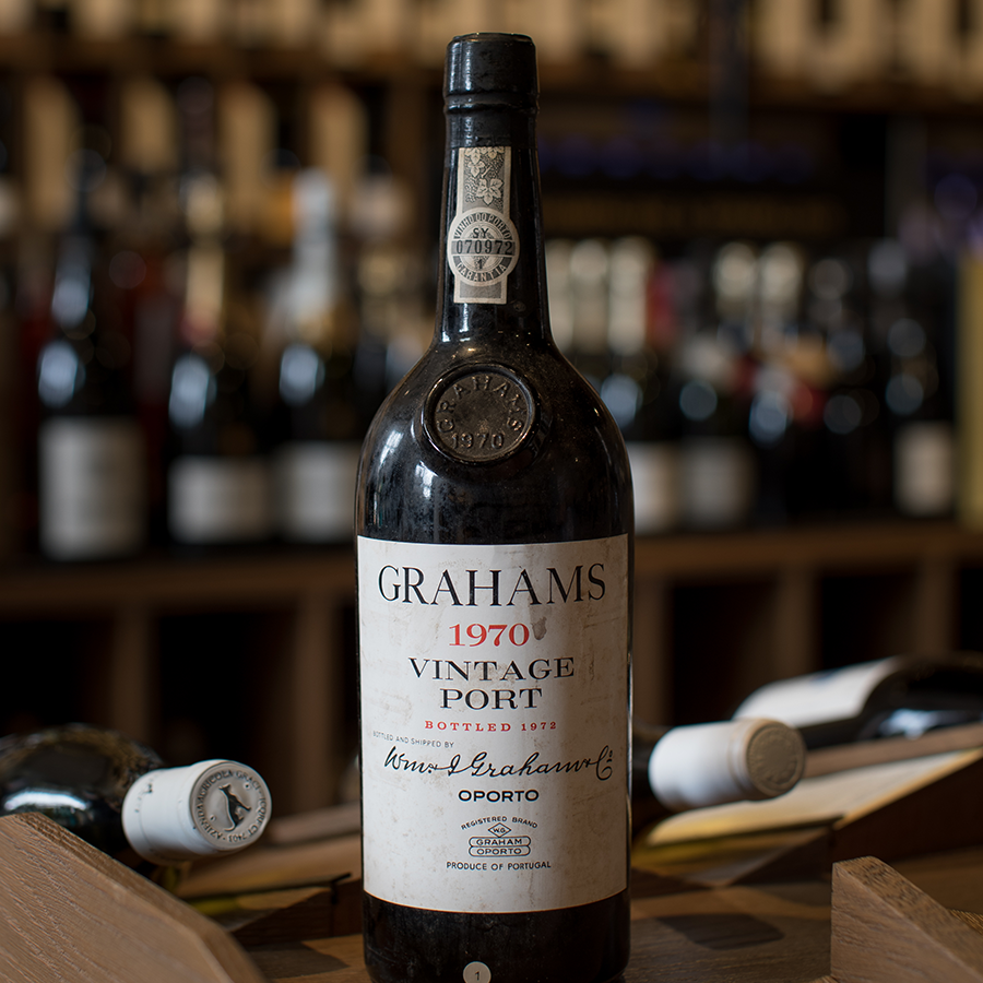 A bottle of Graham's 1970 Vintage Port in our London Shop, against a backdrop of wines stacked on the shelves. 