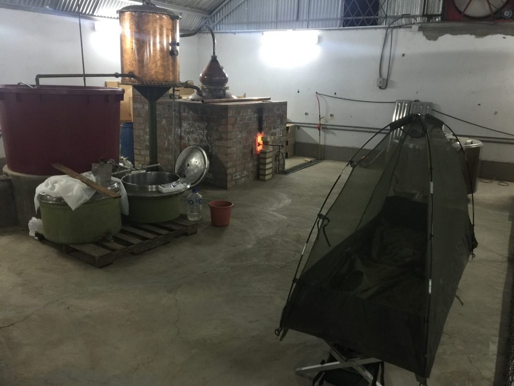 A mosquito tent set up beside a still, where Alex keeps watch